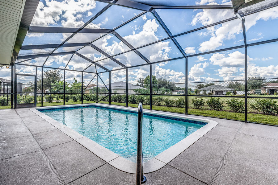 a screen enclosed pool with beautiful view